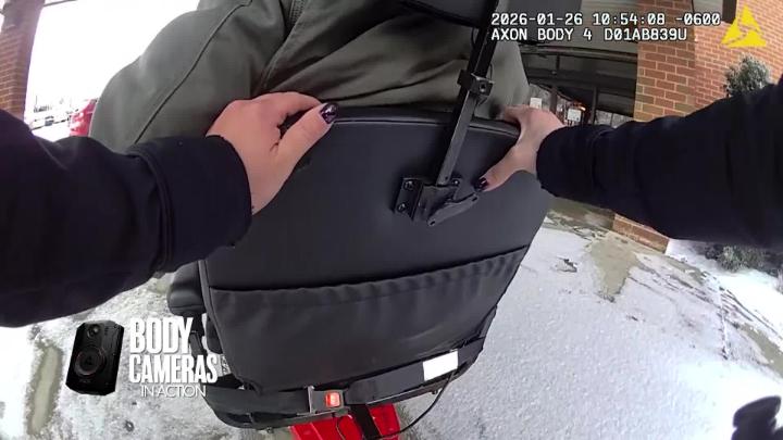 Police officer helping a man in wheelchair that was stuck in the snow