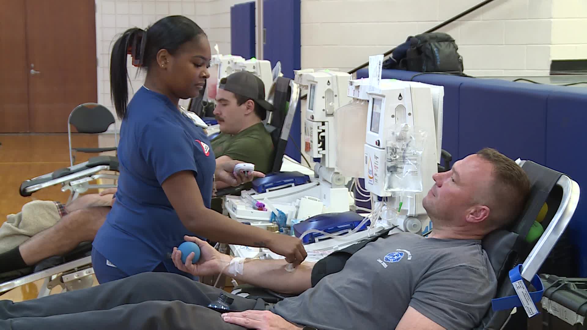 nurse is assisting man donating blood